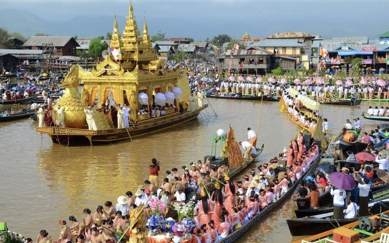 Ornate golden barge and many longboats crowded with rowers and devotees during the Phaung Daw Oo Pagoda festival on Inle Lake, Myanmar.